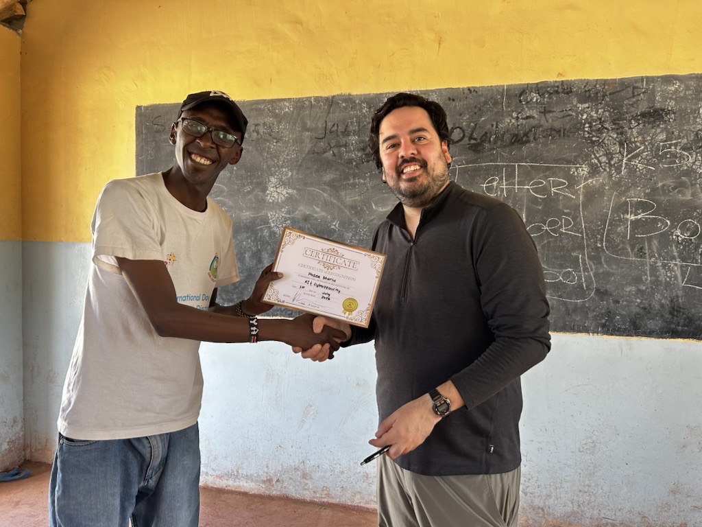 Victor Aldana handing a course completion certificate to a participant in Kenya